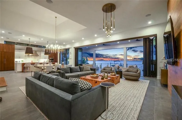 a living room with furniture kitchen view and a large window
