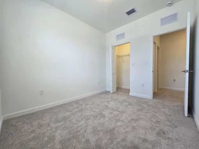 an empty room with windows and closet