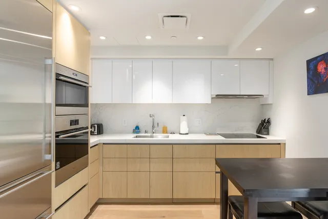 a kitchen with a sink stainless steel appliances and white cabinets