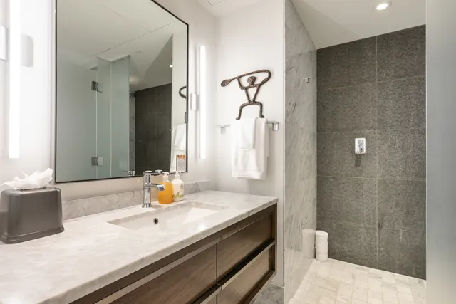 a bathroom with a granite countertop sink and a mirror