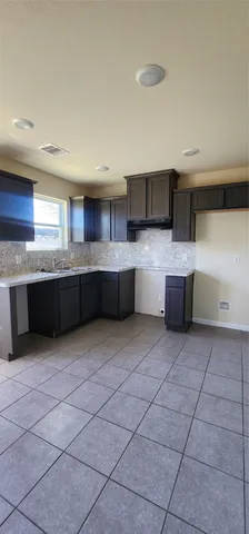 a large kitchen with kitchen island granite countertop a sink and a stove top oven