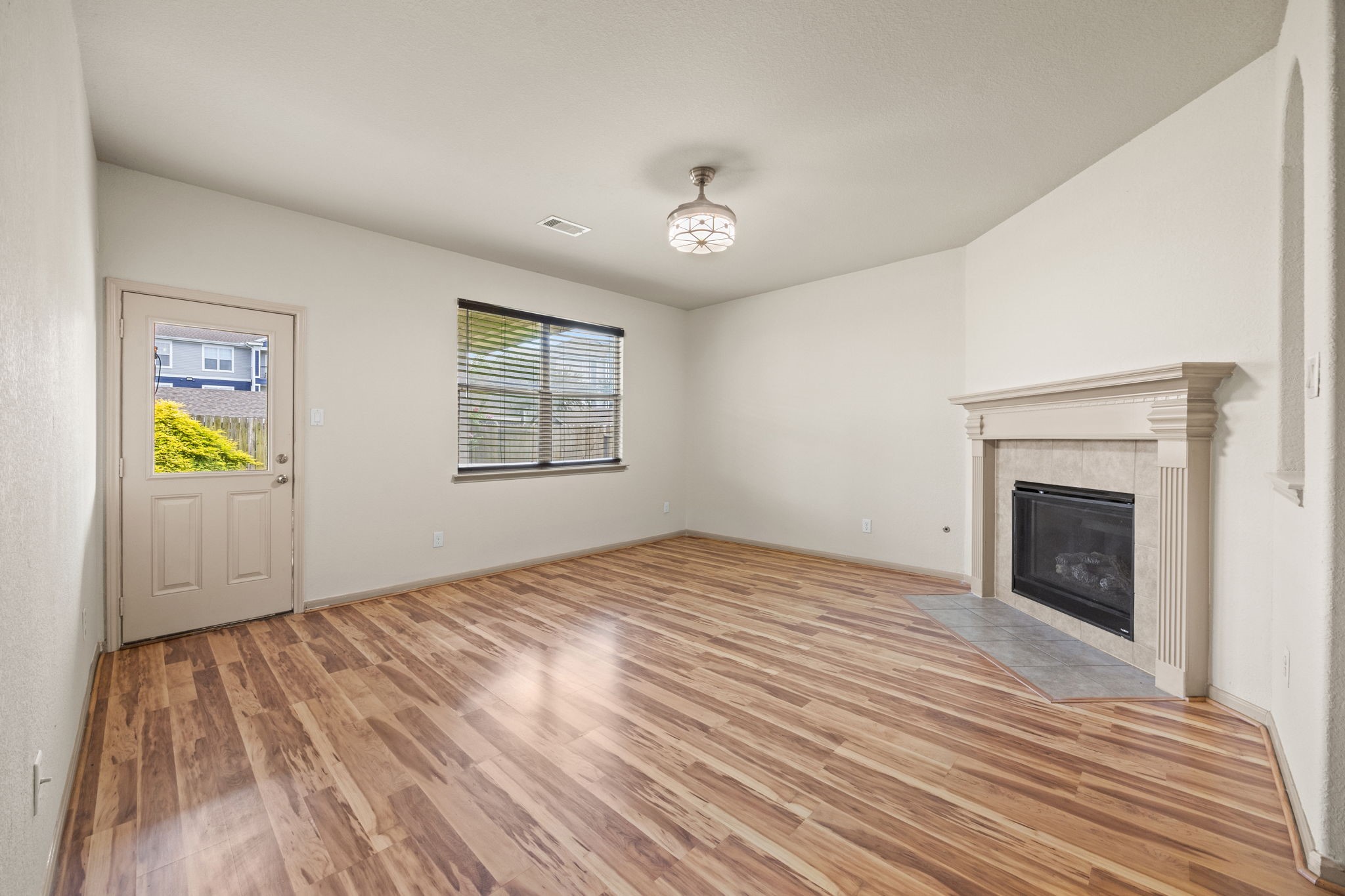 3606 Canvasback Lane Houston, TX 77047 - Photo 12 of 29 Bright and inviting family room featuring wood-look flooring, a cozy gas fireplace with elegant mantel, and an open-concept layout perfect for everyday living and entertaining.