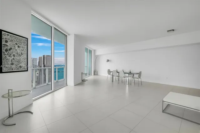 a dining room with furniture and floor to ceiling window
