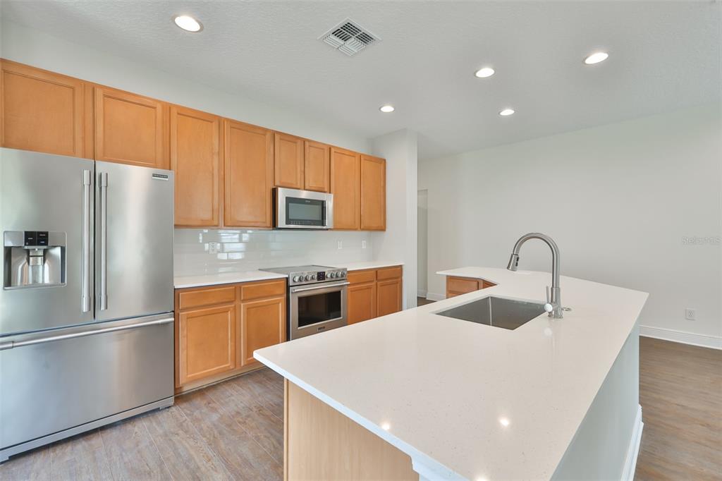708 Coade Stone Drive Seffner, FL 33584 - Photo 14 of 48 a kitchen with stainless steel appliances granite countertop a refrigerator sink and white cabinets