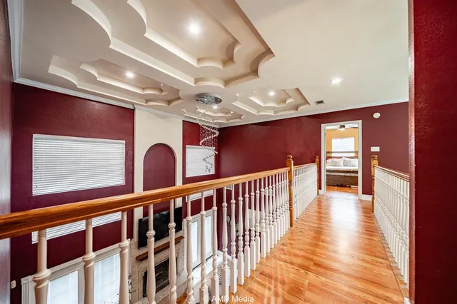a view of a hallway with wooden floor and stairs