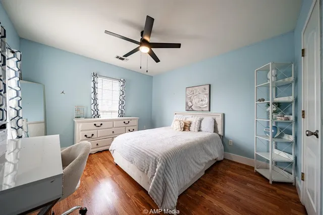 a bedroom with a bed and wooden floor