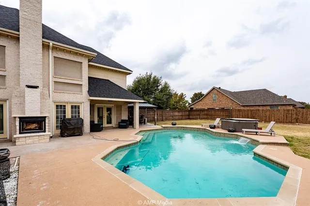 a swimming pool with outdoor seating and yard