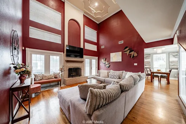 a living room with furniture a fireplace and a dining table with wooden floor