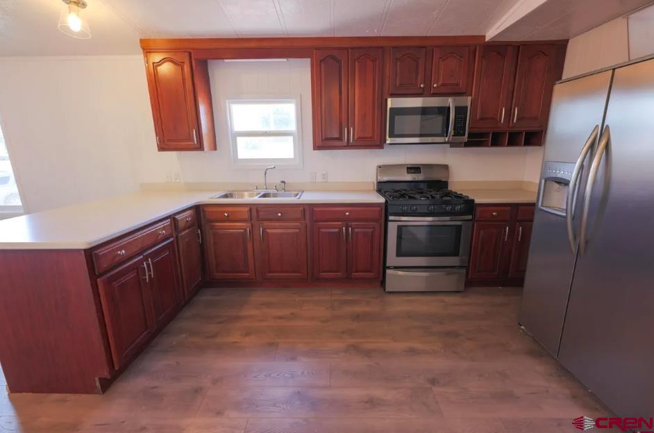 11 Rickey Place Monte Vista, CO 81144 - Photo 12 of 16 a kitchen with stainless steel appliances granite countertop a stove a sink dishwasher a refrigerator and a microwave oven