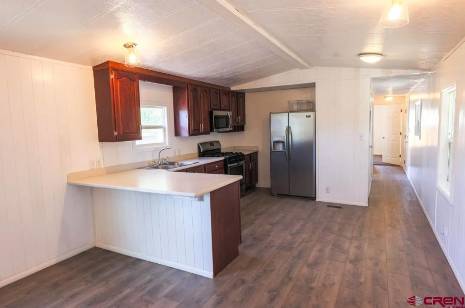 11 Rickey Place Monte Vista, CO 81144 - Photo 14 of 16 a kitchen with stainless steel appliances granite countertop a sink a refrigerator and wooden floor