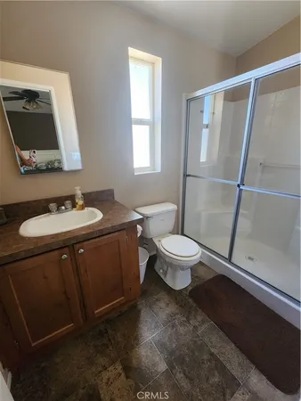a bathroom with a sink a toilet a mirror and shower
