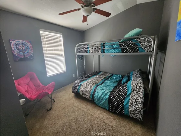 a bed sitting in a bedroom next to a window