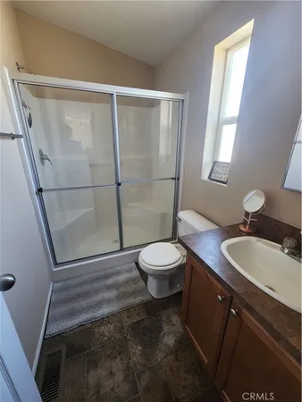 a bathroom with a sink a toilet a mirror and shower