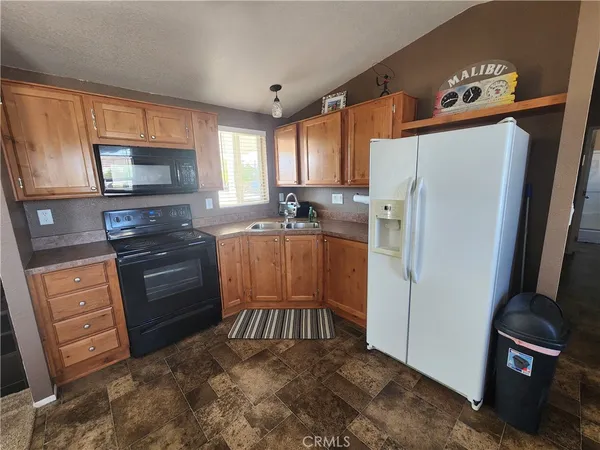 a kitchen with stainless steel appliances granite countertop a refrigerator stove microwave and sink
