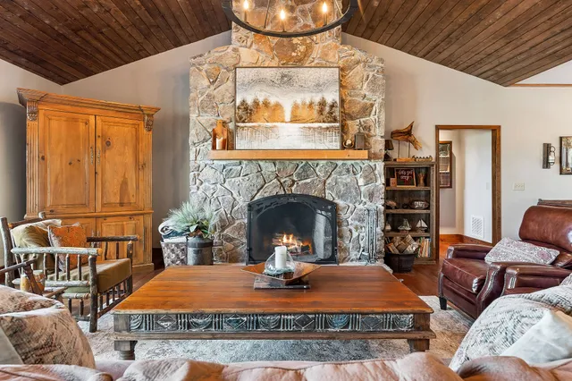 a living room with stainless steel appliances granite countertop a couch and wooden floor