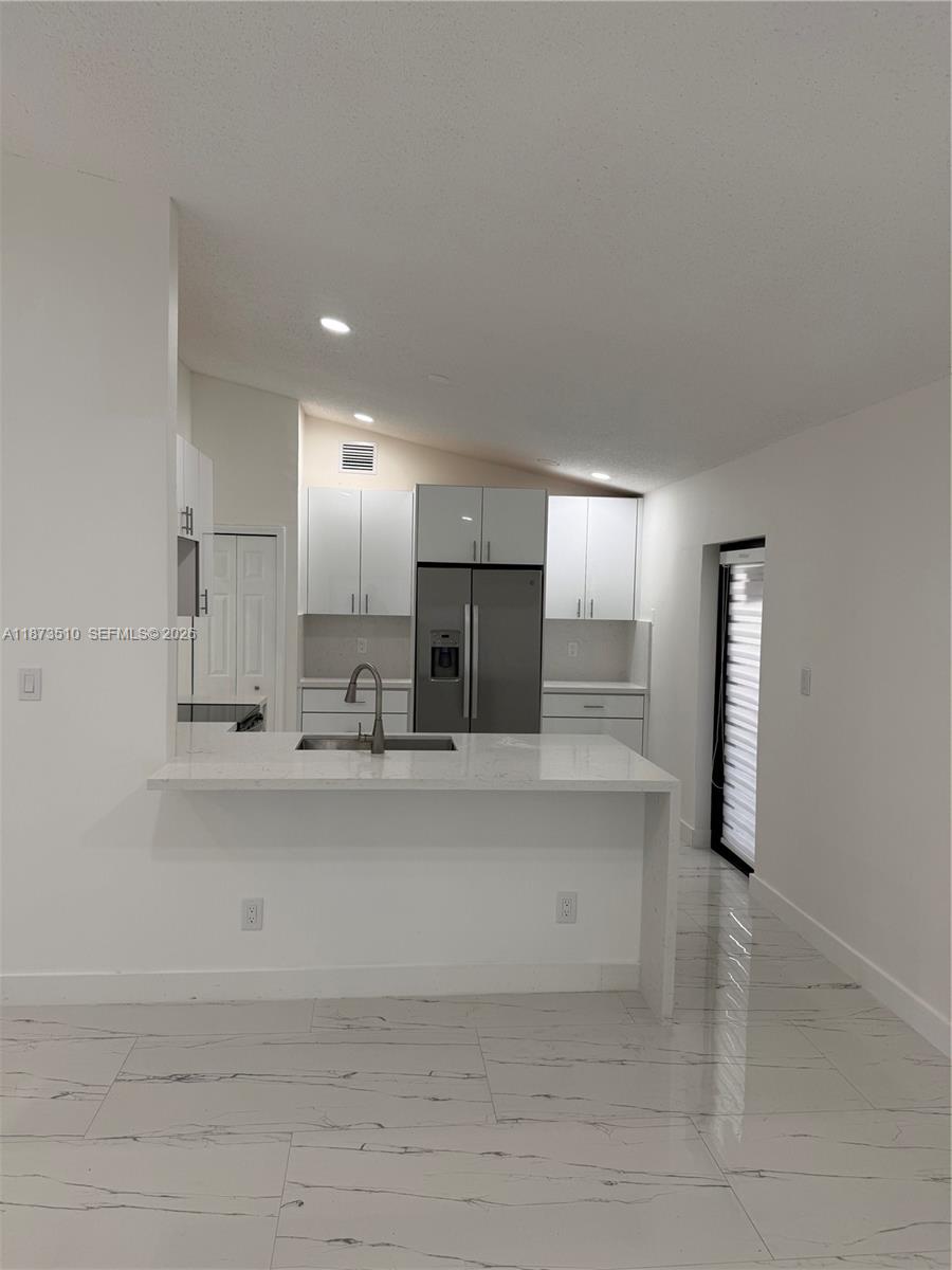 15921 Southwest 82nd Street Miami, FL 33193 - Photo 11 of 20 a large kitchen with kitchen island a sink stainless steel appliances and cabinets
