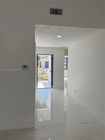 an empty room with windows and door