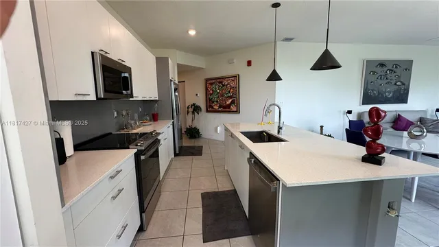 a kitchen with a sink a microwave a stove and refrigerator