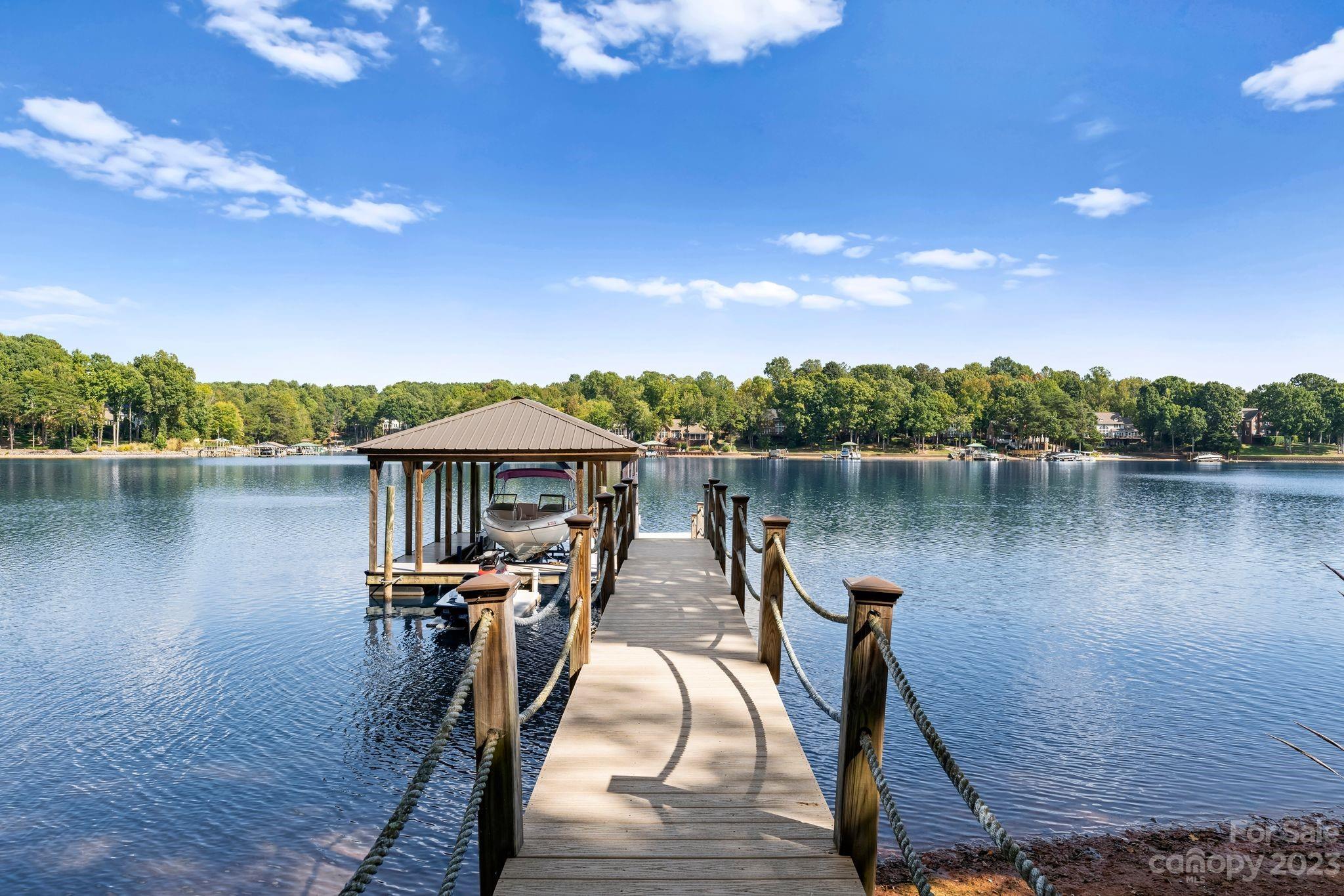 413 Bay Harbour Road Mooresville, NC 28117 - Photo 40 of 47 a view of a lake with a large trees and wooden fence
