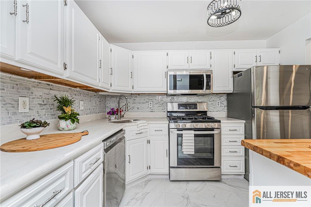 612 Chester Court Helmetta, NJ 08828 - Photo 7 of 31 a kitchen with stainless steel appliances white cabinets and a sink