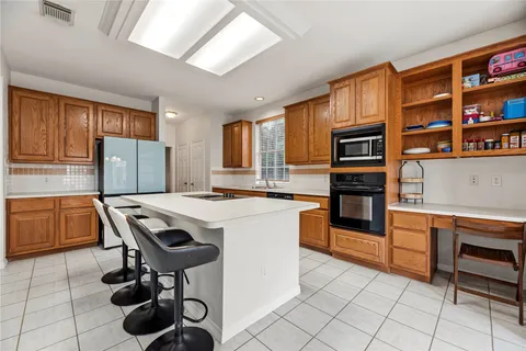 a kitchen with granite countertop a stove chairs and cabinets