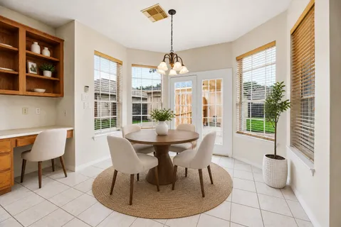 a dining room with furniture a chandelier and wooden floor