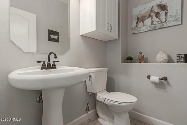 a bathroom with a sink mirror and toilet