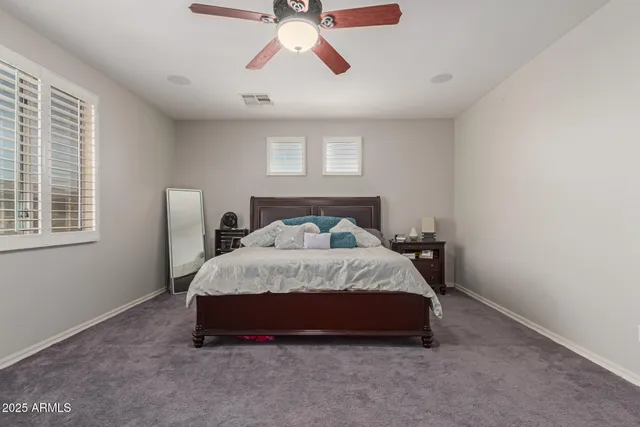 a spacious bedroom with a bed and a window