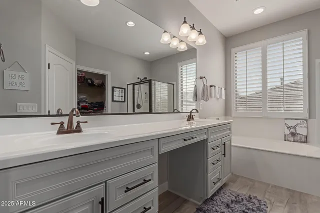 a bathroom with a sink a large mirror and a bathtub