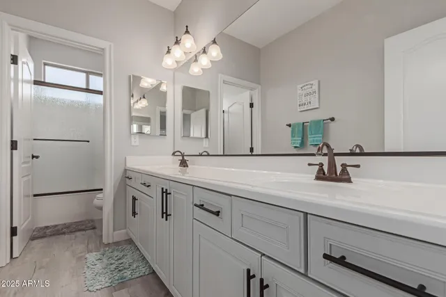 a bathroom with a double vanity sink mirror and shower