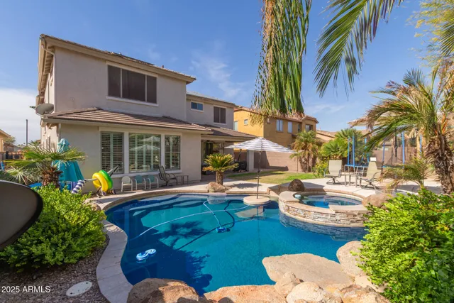 a view of a house with swimming pool and sitting area