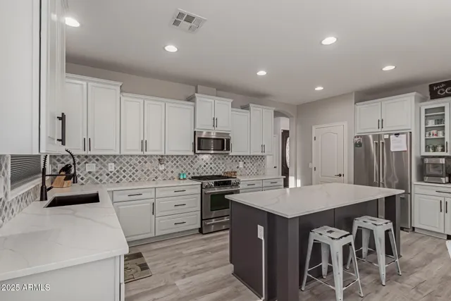 a kitchen with stainless steel appliances granite countertop a sink stove and refrigerator
