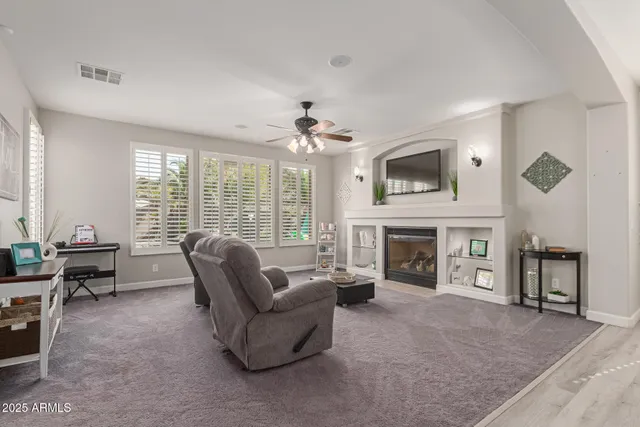 a living room with furniture a fireplace and a large window