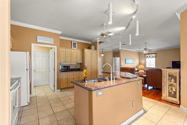 a kitchen with kitchen island a counter top space a sink stainless steel appliances and cabinets