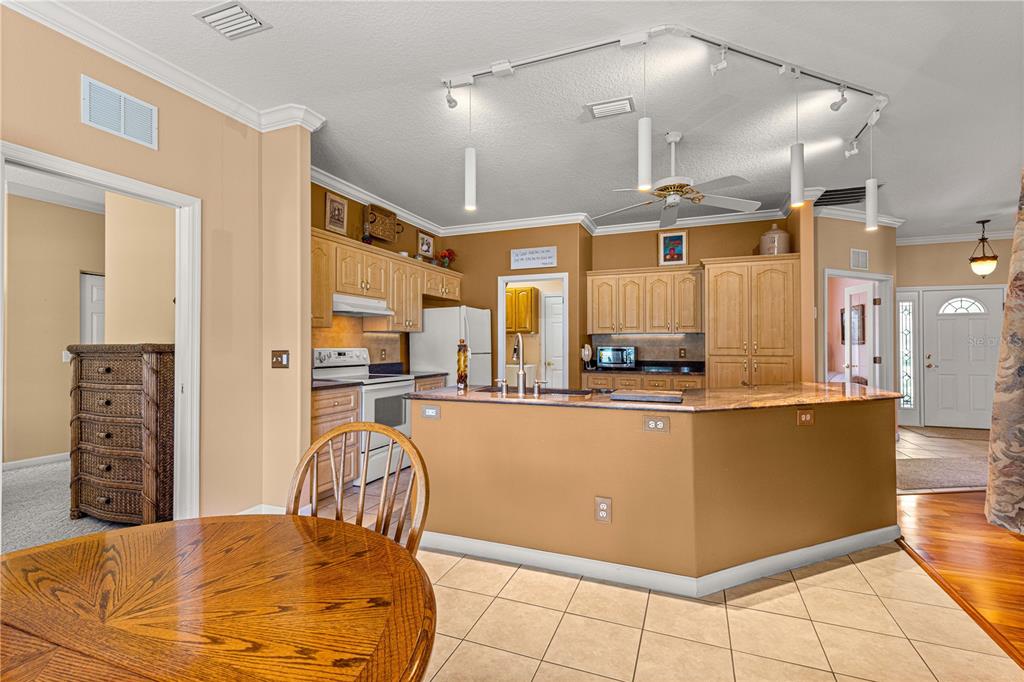5543 Northwest 25th Loop Ocala, FL 34482 - Photo 25 of 50 a kitchen with stainless steel appliances kitchen island granite countertop a refrigerator a stove top oven and a sink