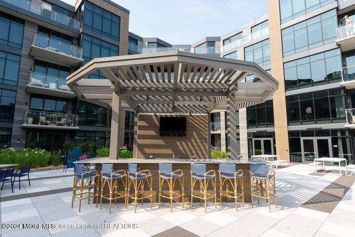 30 Melrose Terrace, Unit 201 Long Branch, NJ 07740 - Photo 23 of 33 a view of a patio with a table and chairs and potted plants