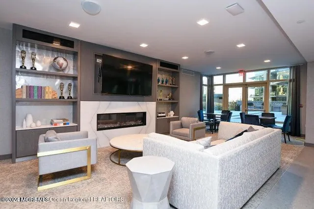 a living room with furniture a large window and kitchen view
