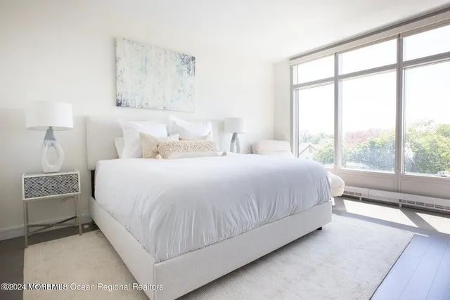 a bedroom with a large bed and a lamp next to a window