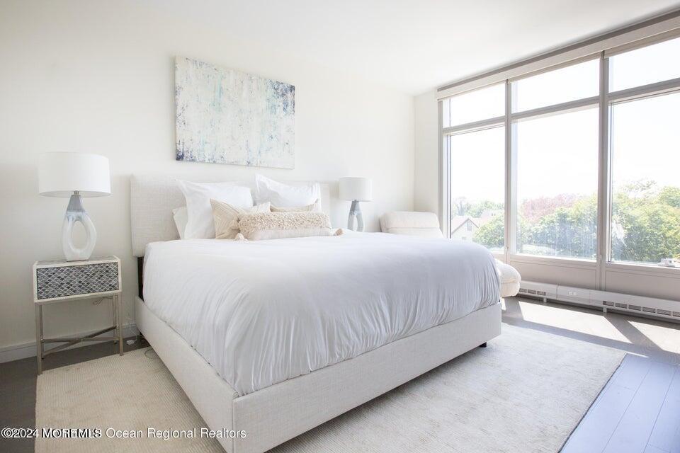 30 Melrose Terrace, Unit 201 Long Branch, NJ 07740 - Photo 5 of 33 a bedroom with a large bed and a lamp next to a window