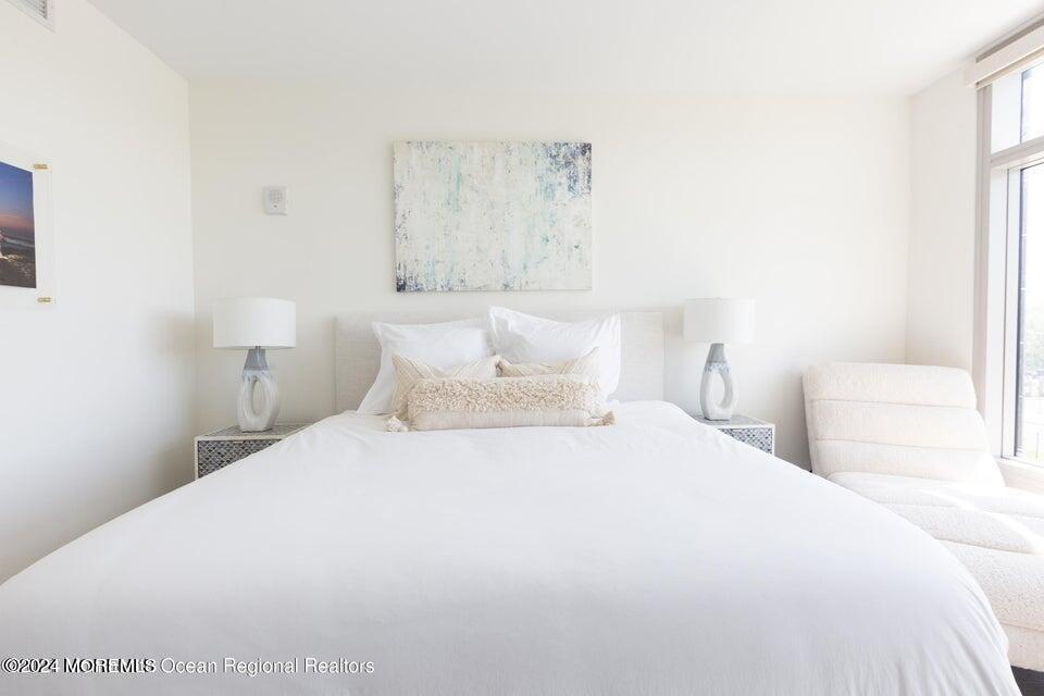 30 Melrose Terrace, Unit 201 Long Branch, NJ 07740 - Photo 6 of 33 a bedroom with a bed and a lamp