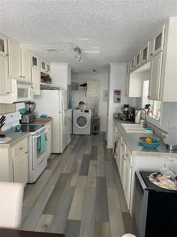 a kitchen that has a lot of cabinets a sink and a stove