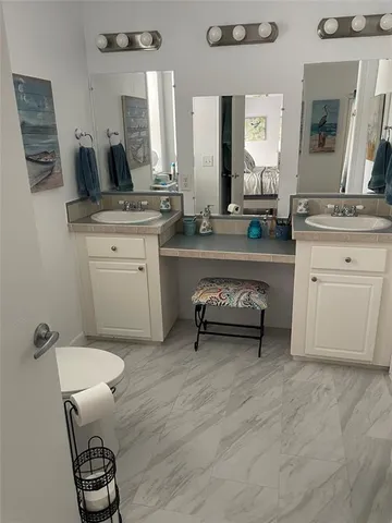 a spacious bathroom with a double vanity sink and a mirror