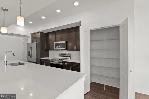 a kitchen with a refrigerator a stove and a sink with wooden floor