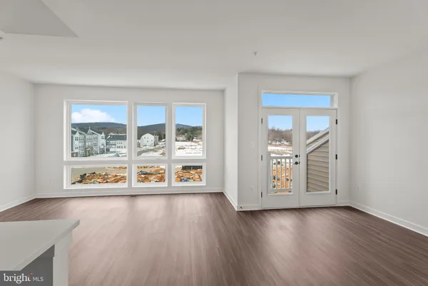 an empty room with window and wooden floor