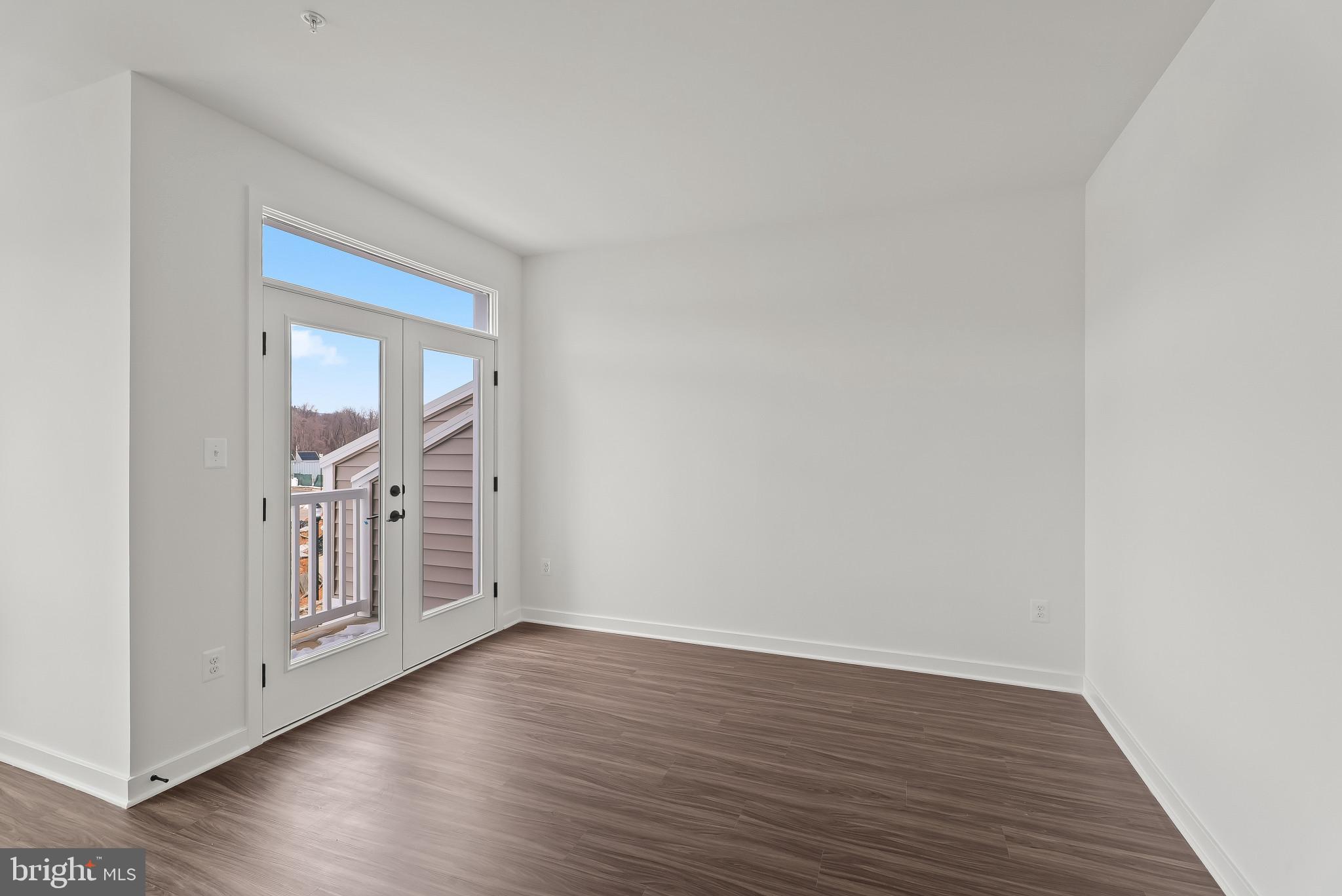 714 D Iron Frg Road Frederick, MD 21702 - Photo 18 of 47 a view of an empty room with wooden floor and cabinet
