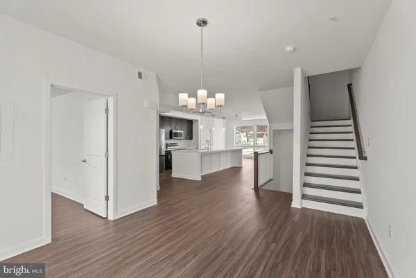a view of a room with wooden floor and kitchen view