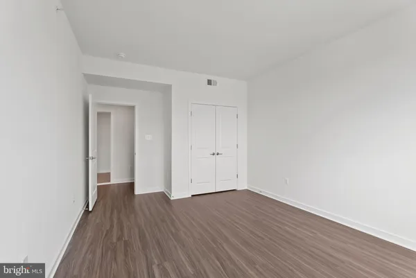 a view of a room with wooden floor and white walls
