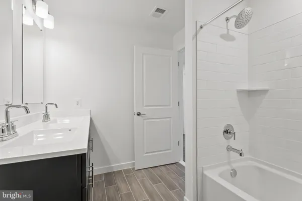 a bathroom with a tub shower vanity and a sink
