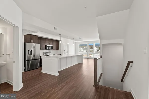a kitchen with a refrigerator and a wooden floor