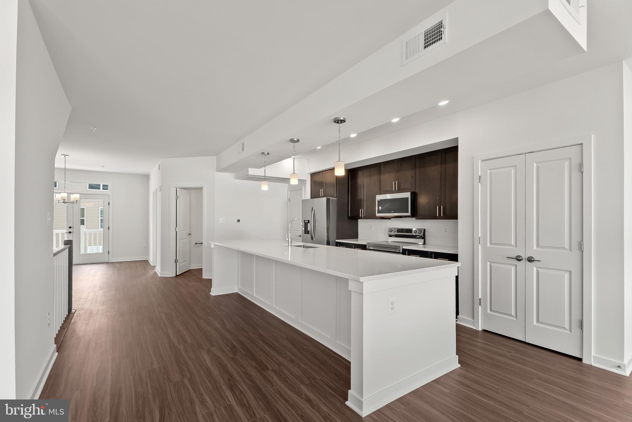 714 D Iron Frg Road Frederick, MD 21702 - Photo 7 of 47 a kitchen with stainless steel appliances a stove top oven a sink a refrigerator white cabinets and wooden floor